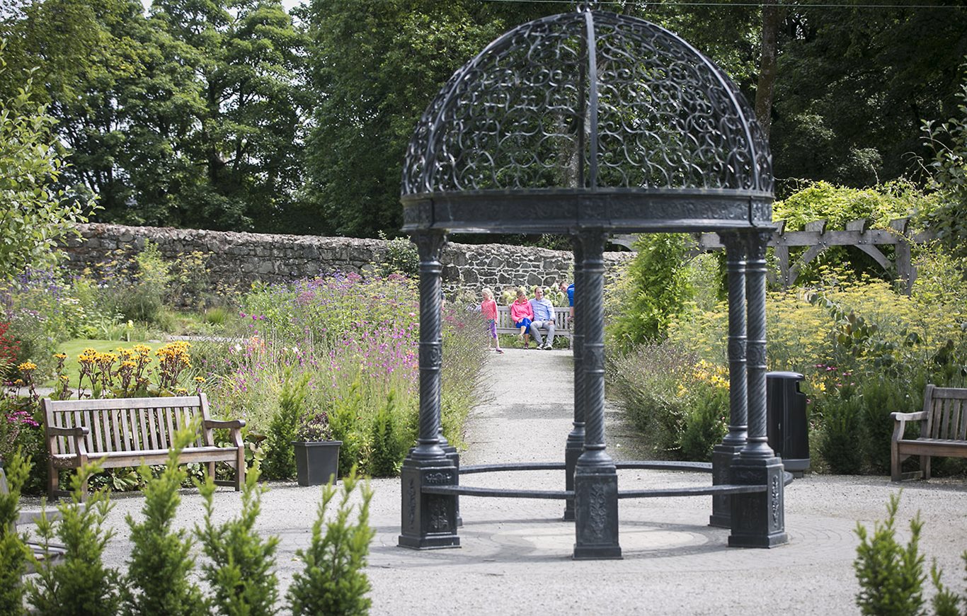 A family sitting in the grounds of Maghera Walled Garden