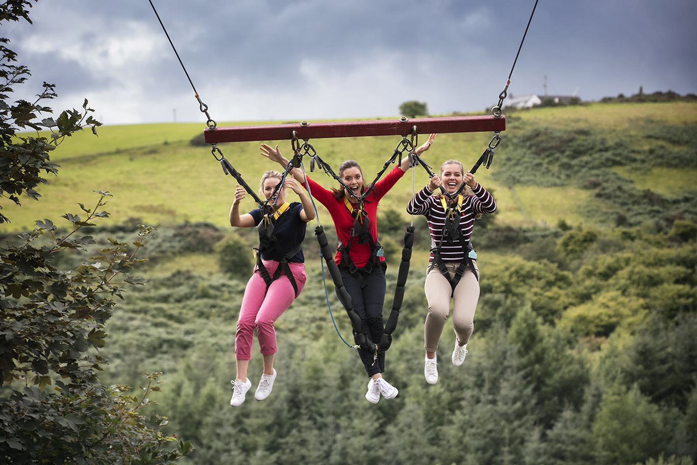 Three girls swinging through the air at Todds Leap
